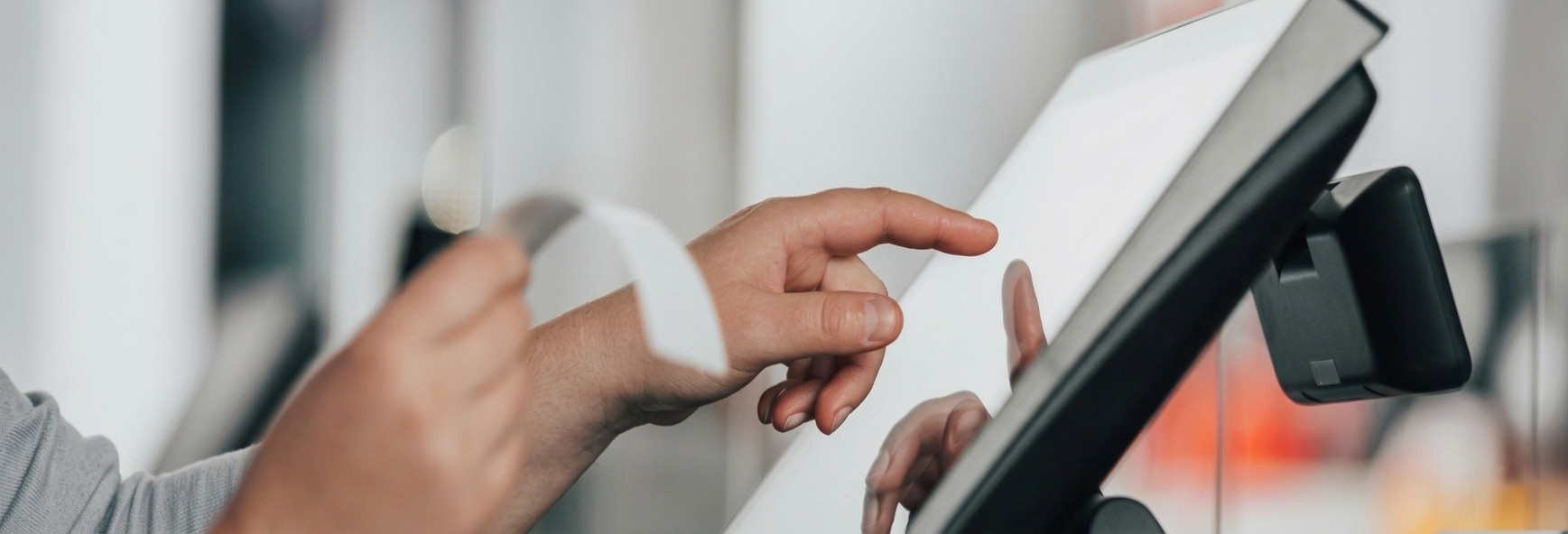 Person using a POS touchscreen — automate business operations with powerful and reliable software systems